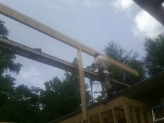 Carpenter setting a ridge beam over a new addition frame — Ice Dam Removal by Roofing Brothers in Uhrichsville