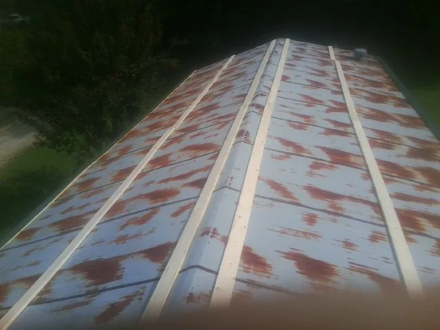Rusted metal roof panels with new wood purlins before replacement — Storm Damage Roof Repair in Uhrichsville by Roofing Brothers