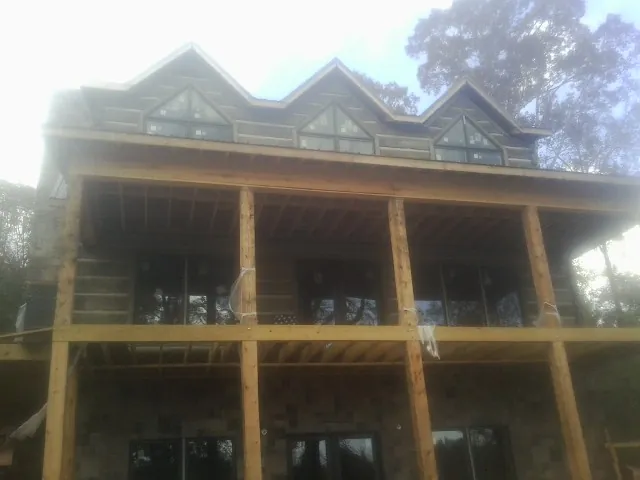 Dormers and porch framing on a large log home under construction — Roof Coating work by our crew in Uhrichsville